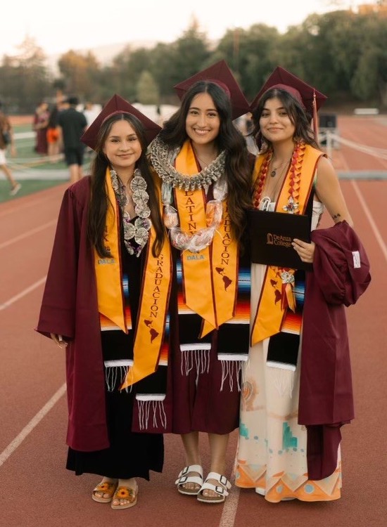 three young women in grad regalia